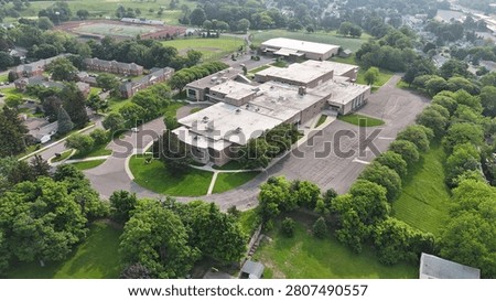 The entire layout of a school educational edifice surrounded by tree canopies.