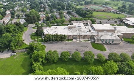 The entire layout of a school educational edifice surrounded by tree canopies.