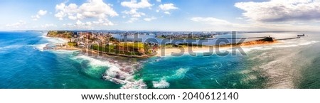 Entire Newcastle city CBD in wide aerial panorama from Pacific ocean facing Hunter Valley and city beaches.