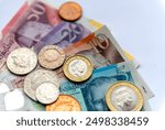 The entire selection of the Pound Sterling physical currency in paper notes and metal coins isolated in a white background.