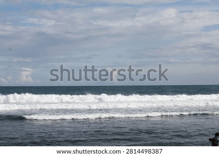 entle ocean waves roll toward the shore beneath a vast sky filled with soft clouds. The peaceful seascape blends deep blue water, white surf, and natural light, creating a calm and refreshing coastal view.