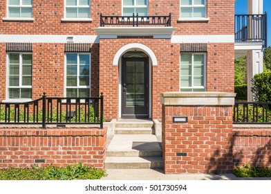 Entrance Of Brand New Apartment Building With Concrete Door Steps And Brick Fence In Front