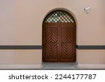 Entrance of building with brown wooden door and CCTV camera