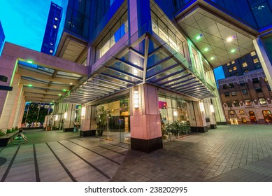 Entrance To The Building Lobby. Night Scene Of Modern Colorful City Life With Skyscrapers, Highrise Buildings. Vancouver Downtown  At Night.