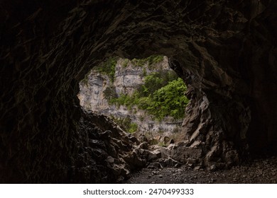 entrance to a cave in the mountain. Mountain cave entrance. with the view of forest. a mountain landscape in spain - Powered by Shutterstock