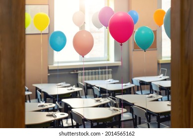 Entrance Door Of Empty Elementary Primary School Interior Furniture Children Desk Decorated With Multicolored Colorful Air Balloons Against Window. Happy Knowledge Day And Back To School Concept