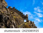 Entrance door and wall of the ruins of Tourbillon castle and Sion hill and city panorama in background in Sion Valais Switzerland