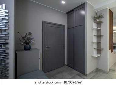 Entrance Door And Wardrobe In Luxury Apartment. Modern Interior. Grey Colors. Decorative Flower.