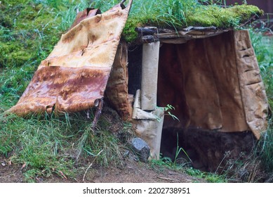 Entrance To An Earthen Hut And A Door Made Of Birch Bark. The Era Of The Paleolithic. Reconstruction.