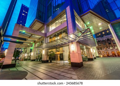 Entrance, Fragment  To The Building Lobby. Night Scene Of Colorful City Life With Skyscrapers, Highrise Buildings. Vancouver Downtown  At Night.