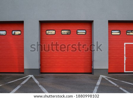 Entrance gate to the fire station. Red automated garage sectional door.