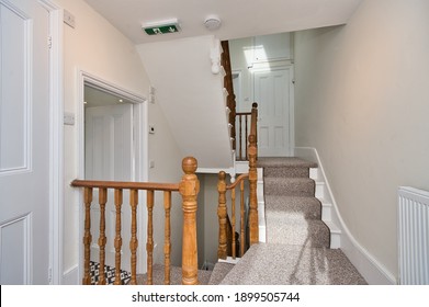 Entrance Hallway And Landing Design With Carpet Runner And Natural Wood Banister