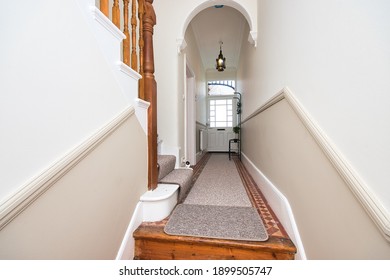 Entrance Hallway And Landing Design With Carpet Runner And Natural Wood Banister