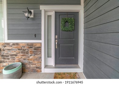 Entrance To A House With Side Light And Gray Front Door Decorated With Wreath