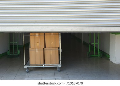 Entrance into self storage units, big cart with carton boxes in front, metal gate - Shutterstock ID 713187070