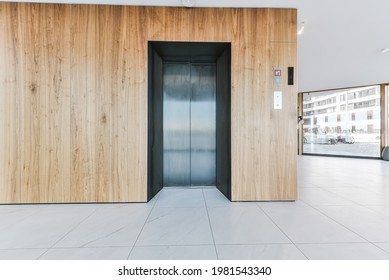 Entrance Lobby Of Luxury Apartment Building With Wooden Wall Panels And Elevator Against Panoramic Windows