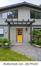 Entrance of a luxury, mid-century modern cottage house with yellow door