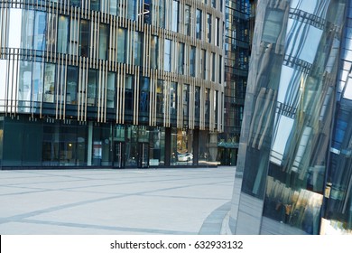 Entrance Of Modern Glass Office Building, Busy City Center Reflected On Its Outer Walls