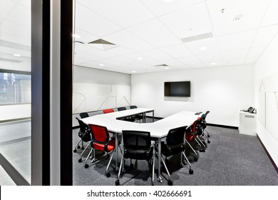 Entrance To A Modern Meeting Room With Door Post Showing Round Table  And Chairs With A Tv