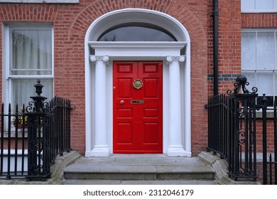 Entrance to old brick townhouse with bright red door - Shutterstock ID 2312046179