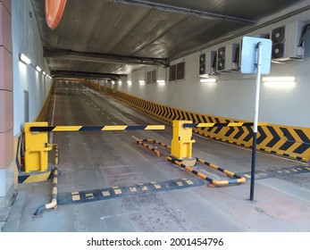 The entrance to the overground parking lot for cars with a barrier and a speed bump.