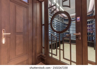 Entrance To A Private Wine Cellar With Shelving. Original Glass Door With Wooden Decor.