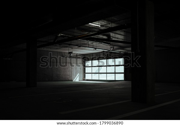 Entrance to underground car park\
during the day. Outdoor area is bright ,indoor area is\
dark.