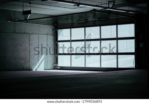 Entrance to underground car park\
during the day. Outdoor area is bright ,indoor area is\
dark.