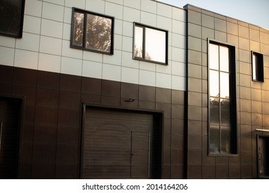 Entrance To The Underground Garage. The Gate To The Garage In The Building. The Office Building Is Brown. A Modern Facing Panel For A Technical Structure. Windows In A Private Office.