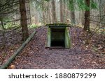 Entrance to underground military bunker in the forest. Former concrete dugout in woodland used during the war