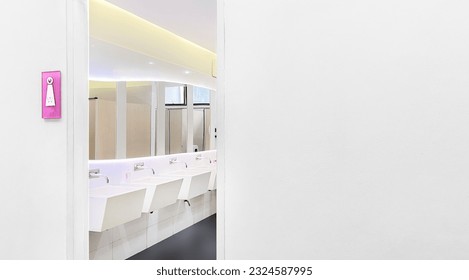 The entrance to the women's restroom is marked with a pink sign. - Shutterstock ID 2324587995