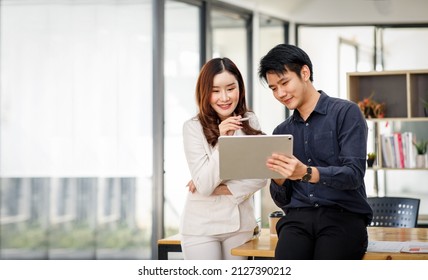 Entrepreneur Asian businessman and businesswoman discussing new business project in tablet in modern Meeting In Modern Office, Asian business casual concept. - Shutterstock ID 2127390212