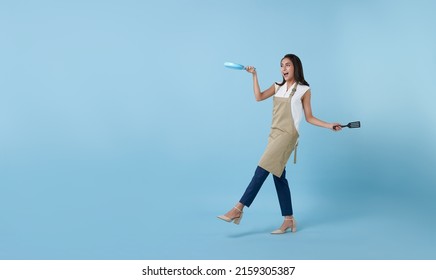 Entrepreneur Asian professional chief ready to cook, Chef holding spatula and frying pan isolated copy space on blue background. - Powered by Shutterstock