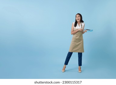 Entrepreneur Asian professional chief ready to cook, Chef holding spatula and frying pan isolated copy space on blue background. - Powered by Shutterstock