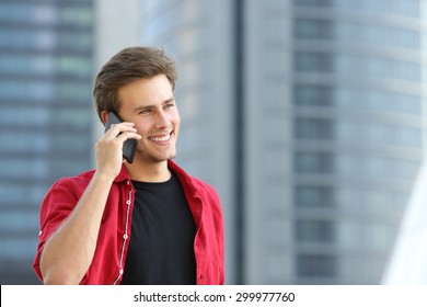 Entrepreneur business man talking on the phone with office buildings in the background - Powered by Shutterstock