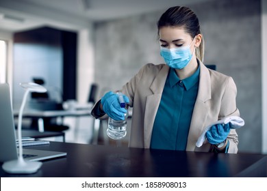 Entrepreneur cleaning her desk with disinfectant while working in the office during COVID-19  pandemic.