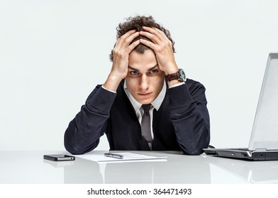 Entrepreneur dissatisfied with his earnings, profit, income, gain, benefit, margin / modern businessman at the workplace working with computer on grey background. Depression and crisis concept - Shutterstock ID 364471493