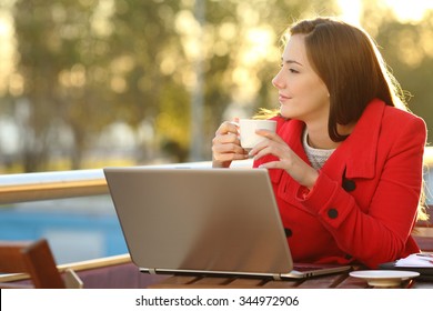 Entrepreneur with a laptop relaxing in a coffee shop and looking forward