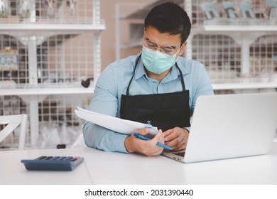 Entrepreneur Male Business Owner In Eyeglasses With Medical Mask Using Computer Laptop Working In Shop Grocery Store, Commercial Crisis Business Debt Concept