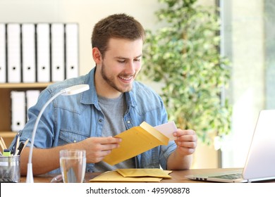 Entrepreneur opening a padded envelope in a desktop at office