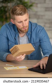 Entrepreneur Opening A Padded Envelope In A Little Office