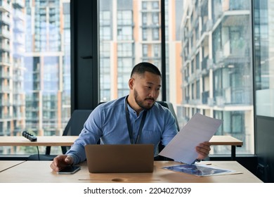 Entrepreneur Reading Business Papers At Office Desk