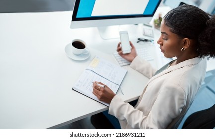 Entrepreneur, Secretary And Admin Assistant Holding Phone While Writing Down Appointments, Schedule And Business Contacts At Her Desk. Professional Woman Doing Online Research And Making Notes