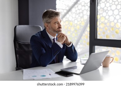 Entrepreneurship Concept. Portrait Of Pensive Handsome Middle Aged Businessman Sitting At Workplace In Office, Thoughtful Mature Entrepreneur Working At Desk With Laptop Computer, Copy Space