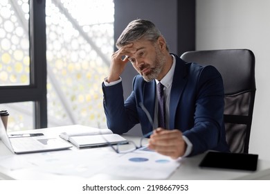 Entrepreneurship Crisis. Depressed Middle Aged Businessman Sitting At Workplace In Office, Pensive Upset Mature Entrepreneur In Suit Suffering Business Problems, Thinking About Solution, Free Space