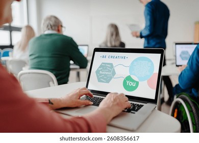 Entrepreneurship program to learn how to start own business. Elderly people attending computer and technology education class.