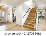 Entry entrance foyer hallway and stair case with wrought iron railings leading into a modern farmhouse style family home.