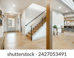 Entry entrance foyer hallway and stair case with wrought iron railings leading into a modern farmhouse style family home.