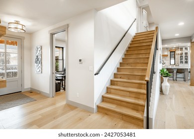 Entry entrance foyer hallway and stair case with wrought iron railings leading into a modern farmhouse style family home. - Powered by Shutterstock