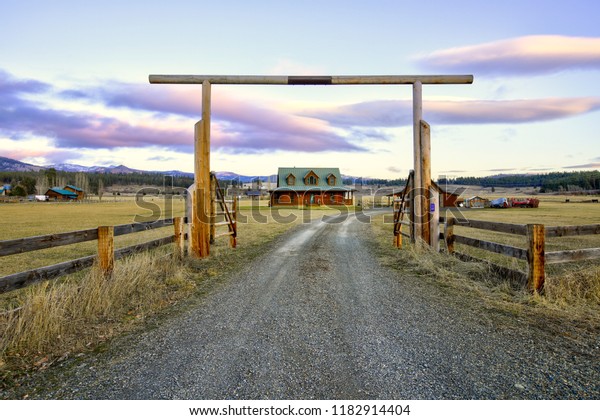 Entry gate to a nice wooden ranch home\
with beautiful landscape. Northwest,\
USA.